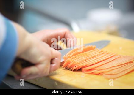 Bis zu schließen. Küchenchef schneiden Fisch für Sushi Stockfoto