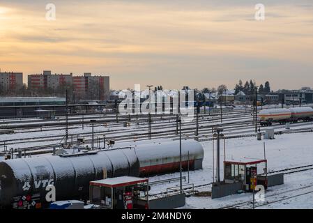 Mühldorf, Deutschland - Dezember 19,2022: Mit Schnee bedeckte Bahngleise an einem Bahnhof Stockfoto