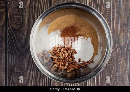 Trockene Zutaten für Kürbis Spice Streusel Topping: Zucker, Pekannüsse und andere Zutaten in einer Rührschüssel, von oben gesehen Stockfoto