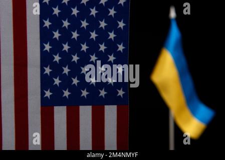 USA Unterstützung in der Ukraine. Die Flagge der Vereinigten Staaten und der Ukraine auf schwarzem Hintergrund Stockfoto