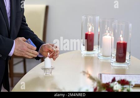 Ein Mann zündet während der Hochzeitszeremonie in Lettland eine Kerze mit einem Streichholz an. Stockfoto