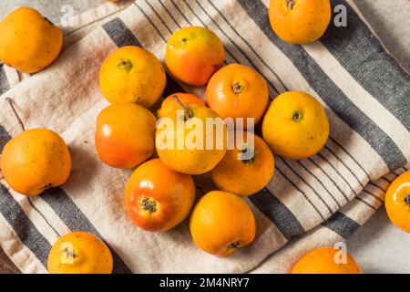 Rohe Orange Organic Tejocote Äpfel in einem Haufen Stockfoto