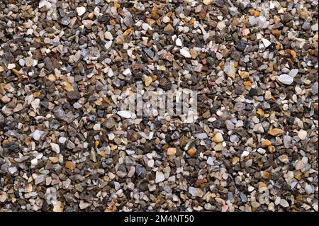 Befeuchten Sie lose Späne, zerkleinerte Steine, Straßen- und Putzkörner, Oberfläche, von oben. Kalk- und eisenfreier Quarzsand, der als Streugut verwendet wird. Stockfoto