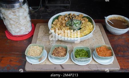 Gewürze aus Chilisauce, Tofu, Kartoffel, Gurke, Bohnensprossen in traditionellem Tontopf Stockfoto