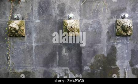 Künstlerischer Duschwasserbrunnen von der Steinwand. Zierhähne klebten an einer Steinwand, normalerweise zum Waschen von Hand, Fuß und Gesicht Stockfoto