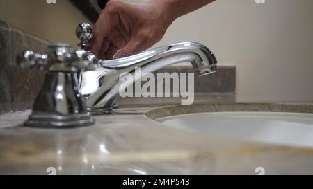 Schließen Sie den modernen Hahn aus Chrom-Edelstahl mit Seifenleiste in der Tafel Stockfoto