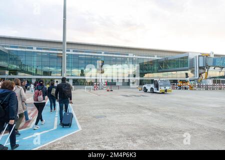 Menschen, die vom Flughafen Mahon, Mao, auf den Balearen, Menorca Spanien, zu Fuß gehen. Stockfoto