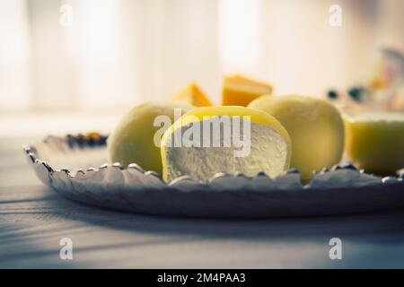 Leckeres Dessert Mochi mit Mangofrucht auf Holzhintergrund, Nahaufnahme. Traditionelles japanisches Reiskuchen-Dessert Stockfoto