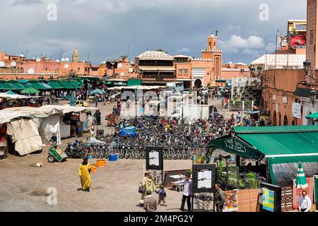 Parkplätze für Zweiräder, Marktstände, Passanten, Restaurants auf dem geschäftigen Marktplatz Djemaa el Fna, Jongleurs Platz, Blick von oben Stockfoto