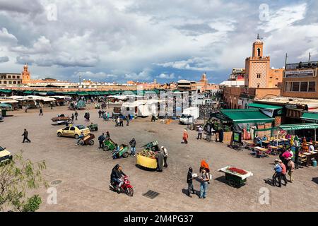 Marktstände, Passanten und Fahrzeuge auf dem belebten Marktplatz Djemaa el Fna, Jongleurs Platz, Blick von oben, Marrakesch, Marokko Stockfoto