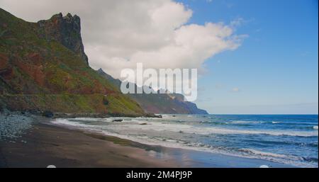 Blick auf die Atlantikküste in Taganana, Teneriffa, Kanarische Inseln, Spanien. Bergkette. Schäumende Wellen treffen auf die felsige Küste. Schwarzer Sandstrand. Stockfoto