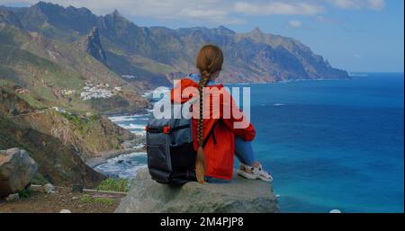 Eine Frau, die das Meer genießt und auf einem Berg auf der Kanarischen Insel Teneriffa sitzt. Wunderschöne Landschaften im Norden der Insel Teneriffa. Stockfoto