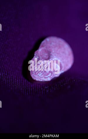 Rosa Schädel Ecstasy-Pille Nahaufnahme Hintergrund qualitativ hochwertige Drucke Purple Army-Drogen Substanz hochdosierte psychedelische Lebensweise Stockfoto