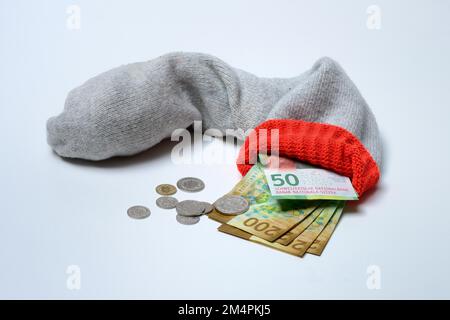 Banknoten in Wollsocken, Sparkassen, Schweizer Banknoten und Münzen Stockfoto