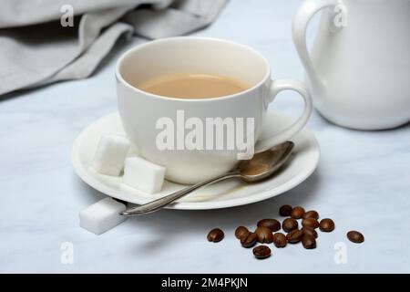 Tasse mit Latte und Kaffeebohnen Stockfoto