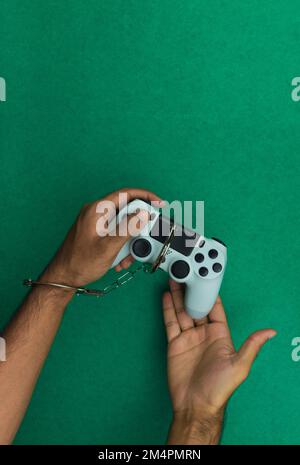 Joystick und Handschellen für Videospiele isoliert. Spielsucht-Konzeptbild Stockfoto