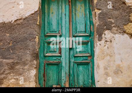 Grüne Holztür, abblätternde Farbe, unterschiedlich verputzte Wand, Argyroupolis, Lappa, Rethymnon-Regionalbezirk, Zentrum von Kreta, Insel Kreta, Griechenland Stockfoto