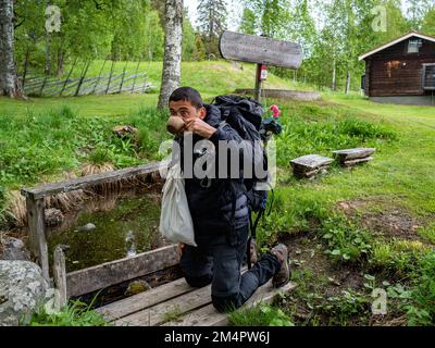 Pilgrimstad, Schweden. 4. Juni 2022. Ein Pilger sah Trinkwasser aus einer dieser Quellen, die oft unterirdische Stauseen sind, aus denen Wasser austritt. Für die meisten ist es üblich, dass immer St. Olavs Legende steht in Verbindung mit ihnen. Die skandinavische Pilgerfahrt ist bekannt als „St. Olavsleden' und ist eine 580km km lange Strecke, die von der Ostsee im Osten zum Atlantischen Ozean im Westen, von SelÃ in Schweden nach Trondheim in Norwegen führt. Dieser Pfad ist das skandinavische Äquivalent zum El Camino de Santiago de Compostela. (Kreditbild: © Ana Fernandez/SOPA Bilder über ZUMA Press Wire) Stockfoto