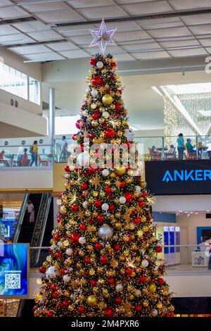 Riesiger Weihnachtsbaum, dekoriert mit Lichtern und verschiedenen Ornamenten Stockfoto