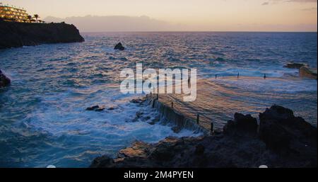 Natürlicher Pool, natürliche Piscina von Acantilados de Los Gigantes bei Sonnenuntergang. Küste am Meer in der Stadt Puerto de Santiago, Teneriffa. Kanarische Inseln, Spanien. Stockfoto