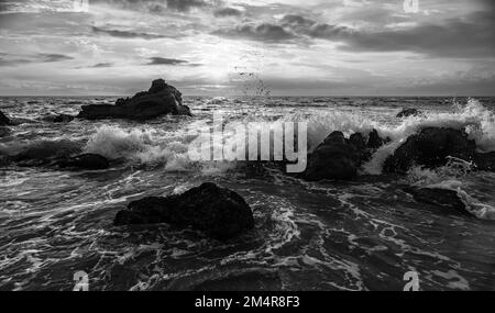 Eine Meereswelle Bricht Gegen Den Sonnenuntergang In Dramatischem Schwarz-Weiß-Bildformat Mit Hoher Auflösung Stockfoto