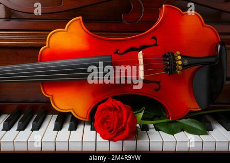 Wunderschöne Rote Rose mit barocker Violin auf den Piano Keys Stockfoto