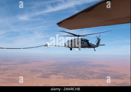 Die dem 26. Expeditionary Rescue Squadron zugeteilten Besatzungsmitglieder führen Hubschrauberbetankungen von einem HC-130J Combat King II mit HH-60G Pave Hawk Hubschraubern durch, die der 46. Expeditionary Rescue Squadron während einer Agile Combat Employment (ACE) Übung innerhalb der USA zugeteilt wurden Verantwortungsbereich des Zentralkommandos, 12. Dezember 2022. Die ACE-Übung ermöglichte es Piloten, ihre Kampfsuche und -Rettung zu verbessern, indem sie die Reichweite von HH-60G-Hubschraubern in einem Spargebiet ausweiten. (USA Air Force Foto von Tech. Sgt. Daniel Asselta) Stockfoto