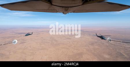 Die dem 26. Expeditionary Rescue Squadron zugeteilten Besatzungsmitglieder führen Hubschrauberbetankungen von einem HC-130J Combat King II mit HH-60G Pave Hawk Hubschraubern durch, die der 46. Expeditionary Rescue Squadron während einer Agile Combat Employment (ACE) Übung innerhalb der USA zugeteilt wurden Verantwortungsbereich des Zentralkommandos, 12. Dezember 2022. Die ACE-Übung ermöglichte es Piloten, ihre Kampfsuche und -Rettung zu verbessern, indem sie die Reichweite von HH-60G-Hubschraubern in einem Spargebiet ausweiten. (USA Air Force Foto von Tech. Sgt. Daniel Asselta) Stockfoto