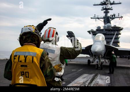 221217-N-MU675-1166 PACIFIC OCEAN (17. Dezember 2022) Aviation Boatswain’s Mate (Handling) 1. Class Eric Arnold, Left, aus Durham, N.C., Und Kapitän Patrick Baker, Executive Officer des Flugzeugträgers USS Abraham Lincoln (CVN 72) der Nimitz-Klasse, aus Silver Spring, Md., leitet eine EA-18G Growler, die der Electronic Attack Squadron (VAQ) 129 zugeteilt ist, auf dem Cockpit. Abraham Lincoln führt derzeit Routineeinsätze in der US-3.-Flotte durch. (USA Marinefoto von Mass Communication Specialist 3. Class Han Puyu) Stockfoto