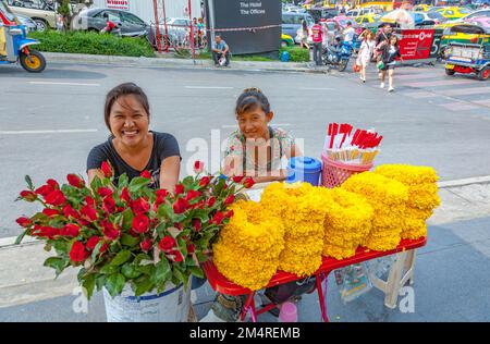 Bangkok, Thailand - 11. Mai 2009: Frauen mit Blumen an einem kleinen Tisch in der Innenstadt von Bangkok verdienen Geld, indem sie Blumen auf der Straße verkaufen. Stockfoto