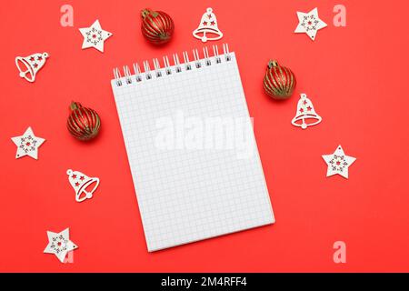 Hintergrund für Weihnachten Neujahr 2023 Weißes Notizbuch für Wünsche, Ziele, Rezepte, Pläne, Lösungen für den Beginn des neuen Jahres auf rotem Hintergrund zu Weihnachten Stockfoto