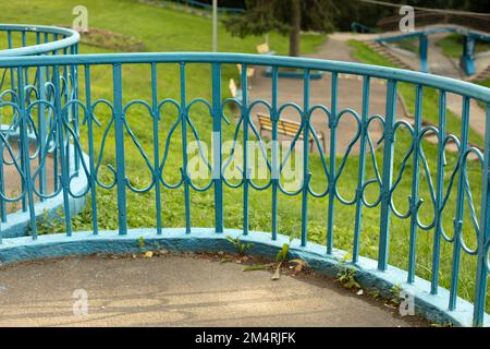 Zaun im Park. Blauer Zaun. Details der Parkarchitektur. Schmiedeeisen. Blauer Kühlergrill. Stockfoto