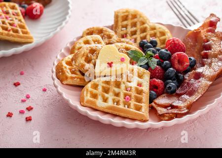 Valentinstag-Frühstück für zwei Personen mit Waffeln in rosa Herzform Stockfoto