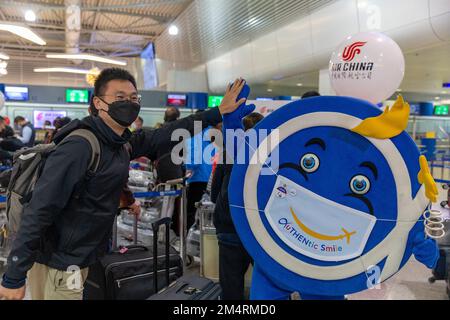 Athen. 22. Dezember 2022. Am 22. Dezember 2022 posiert ein Passagier am internationalen Flughafen Athen in Griechenland für ein Foto mit einem Flughafenmaskottchen. Air China startete am Donnerstag am Internationalen Flughafen Athen (AIA), dem ersten Direktflug zwischen den beiden Städten, einen neuen Direktflug zwischen dem chinesischen Shanghai und dem griechischen Athen. Kredit: Marios Lolos/Xinhua/Alamy Live News Stockfoto