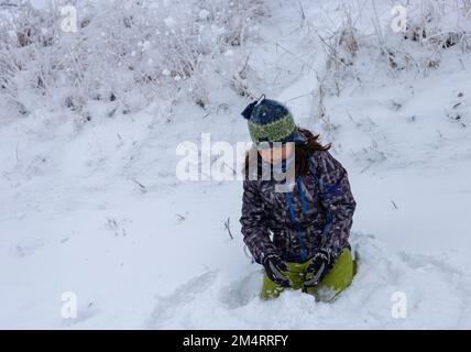 Ein kleiner Junge spielt im Schnee Stockfoto