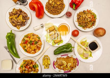 Bambusfleisch mit Pilzen, Frühlingsrollen, gewürzten Garnelen, Zitronenhähnchen, süßen und sauren Schweineknödeln, gebratener Reis aus Sojabohnen, Sojasauce, Gold Stockfoto