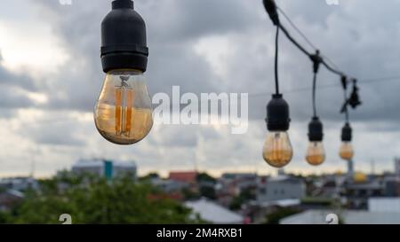 Die Lampen hängen am Nachmittag. Die Lampen sind an. Eine Reihe von Lampen in einem Café Stockfoto
