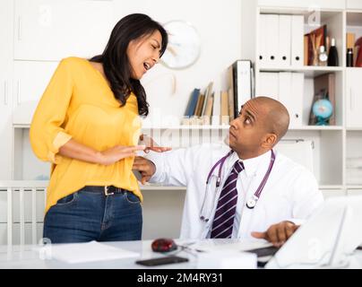 Arzt untersucht Patienten mit akuten Schmerzen Stockfoto