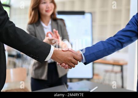 Zwei erfolgreiche Geschäftsleute, die sich nach einem Geschäftstreffen die Hand schütteln. Erfolgreich, Partnerschaft, willkommen, Herzlichen Glückwunsch. Nahaufnahme Stockfoto