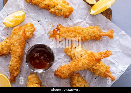 Tempura-Shrimps auf einem Brett serviert mit süßer und saurer Sauce und Zitronenspalten, Vorspeisenidee Stockfoto