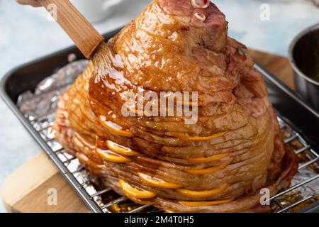 Oster- oder Weihnachtsschinken, Glasur mit Orangenglasur, gefüllt mit Orangenscheiben Stockfoto
