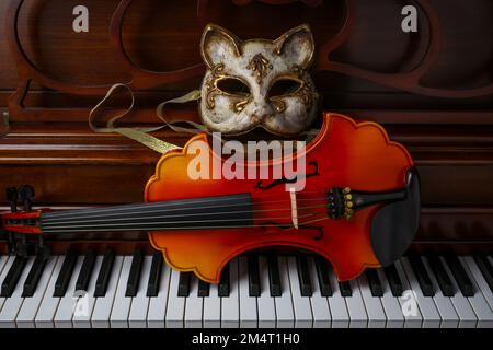 Katzenmaske Und Barocke Violin Auf Piano Keys Still Life Stockfoto