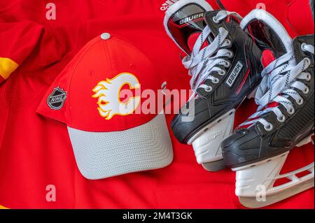 Calgary, Alberta - 22. Dezember 2022: C Calgary Flames NHL-Team Baseballkappe und Trikot mit Bauer-Skates. Stockfoto