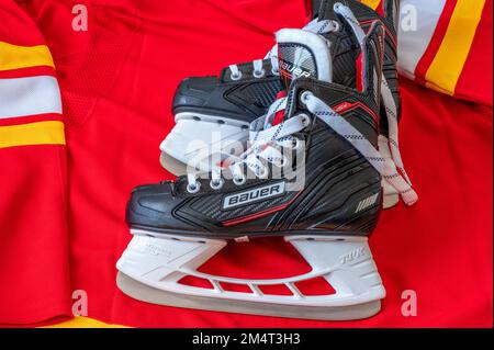 Calgary, Alberta - 22. Dezember 2022: C Calgary Flames NHL-Team Baseballkappe und Trikot mit Bauer-Skates. Stockfoto