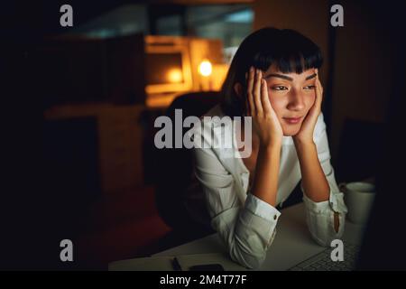 Sie müssen wach bleiben... eine junge Geschäftsfrau, die sich müde fühlt, wenn sie spät in der Nacht auf der Arbeit ist. Stockfoto