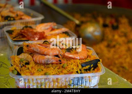 Meeresfrüchte-Paella in Kunststoffbehältern in Paris, Frankreich. Stockfoto