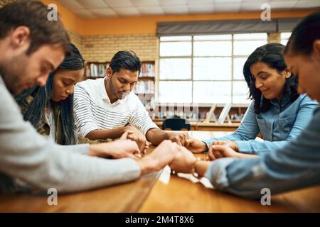 Lasst uns beten. Eine Gruppe von Studenten, die um Hilfe bei ihren anstehenden Prüfungen beten. Stockfoto