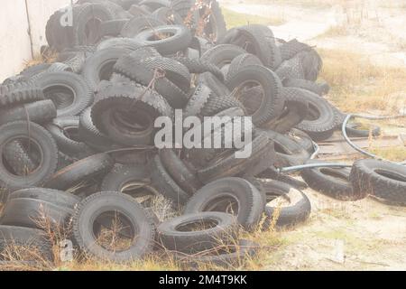 Altreifen liegen auf einer ukrainischen Deponie auf dem Boden, ein Umweltproblem der Branche Stockfoto