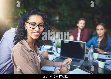 Es ist ein zwangloses und komfortables Brainstorming. Porträt einer jungen Designerin, die sich mit ihren Kollegen in einem Café trifft. Stockfoto