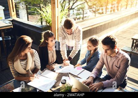 Stickige Vorstandssitzungen sind nichts für dieses Team. Eine Gruppe von Kollegen, die sich draußen in einem Café treffen. Stockfoto
